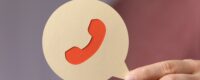Hand holding a paper phone icon